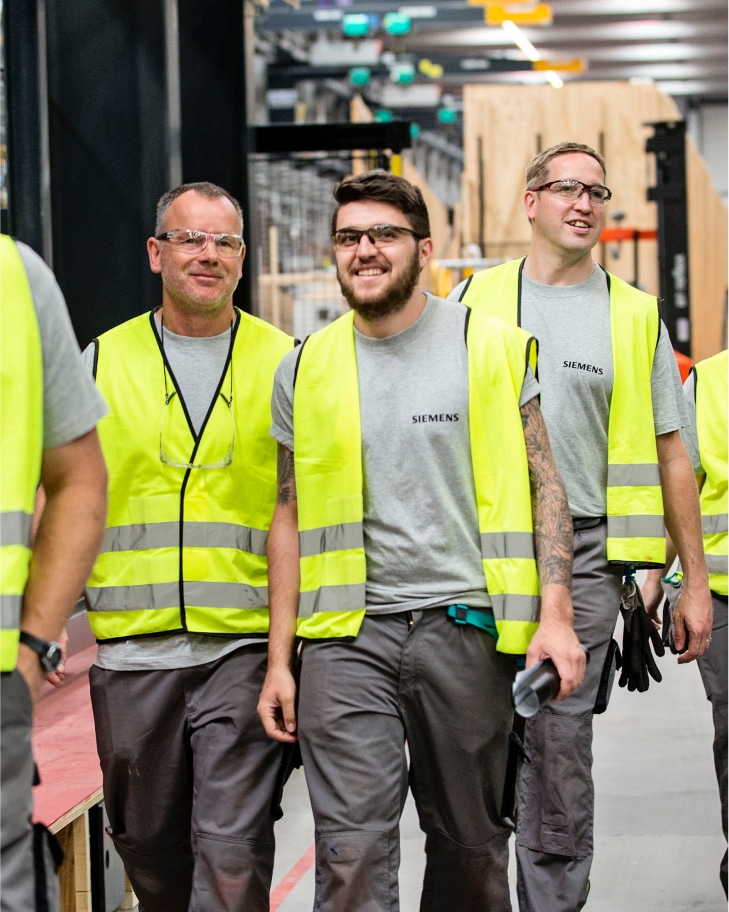 Siemens - A group of men in high-vis vests and safety goggles walking together