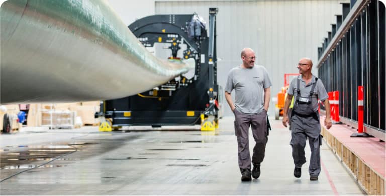 Siemens - Two men walking together and talking at wind-turbine-blade factory in Hull